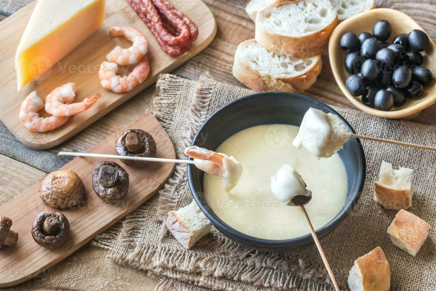 Bowl of fondue with appetizers photo