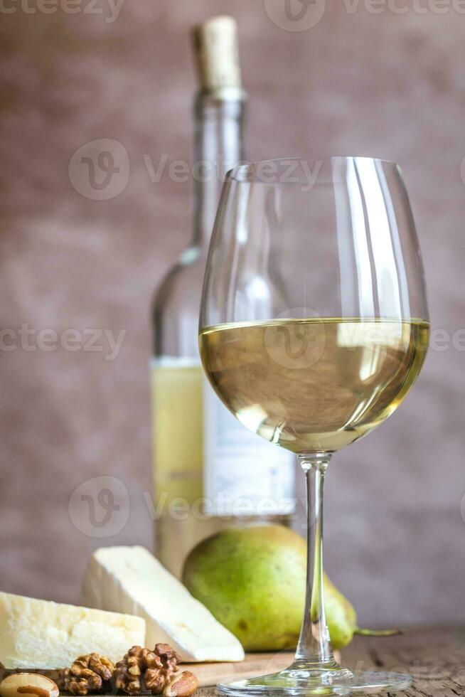 Glass of white wine with cheese and nuts photo