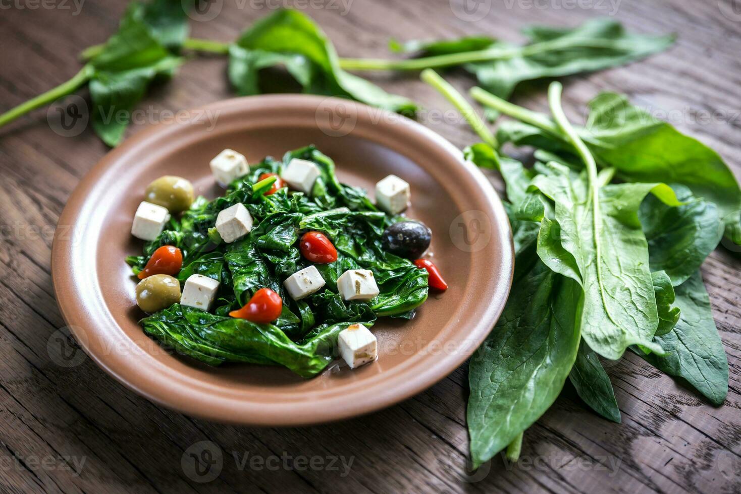 Spinach with cheese, olives and pepper drops photo