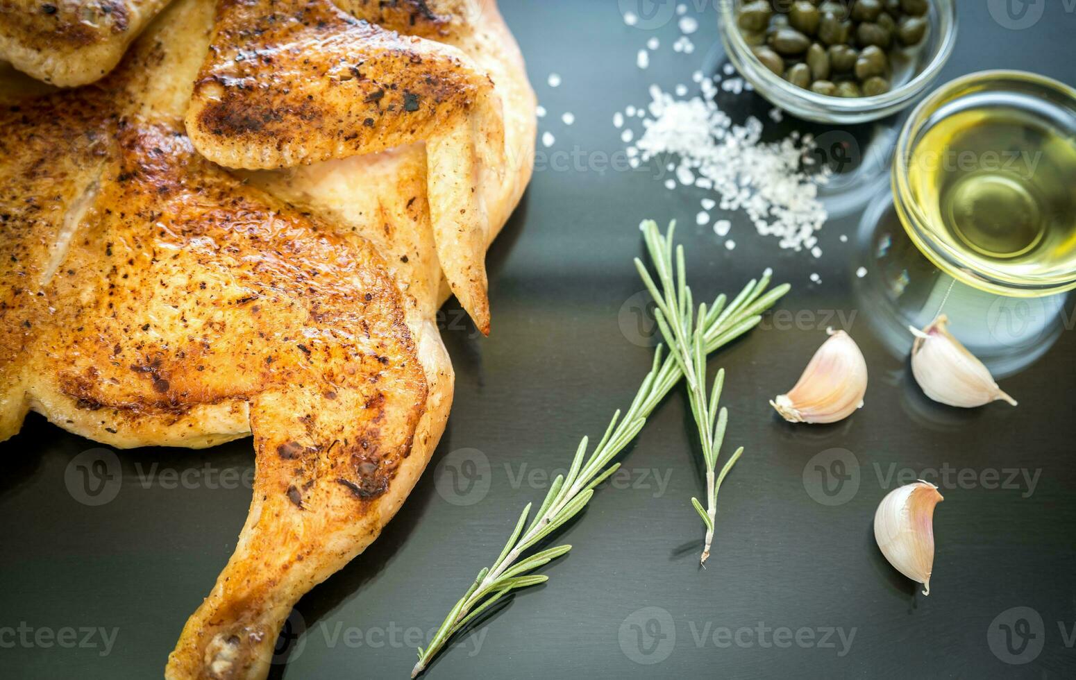 Grilled chicken with ingredients on the dark wooden background photo