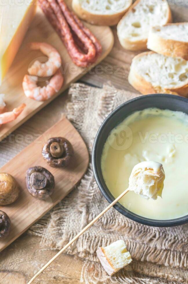 Bowl of fondue with appetizers photo