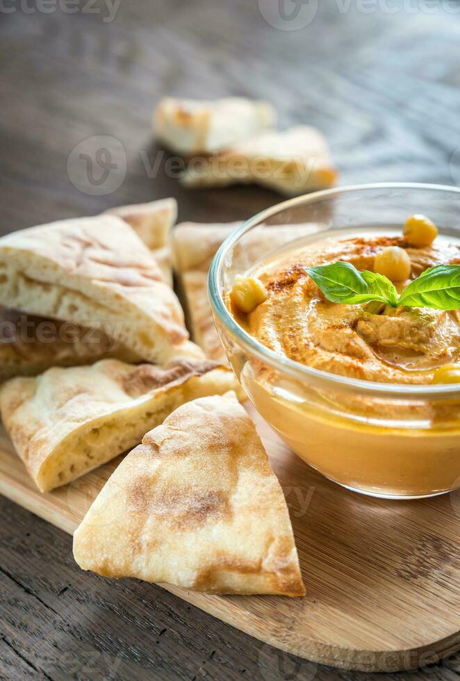 A bowl of hummus with pita slices photo