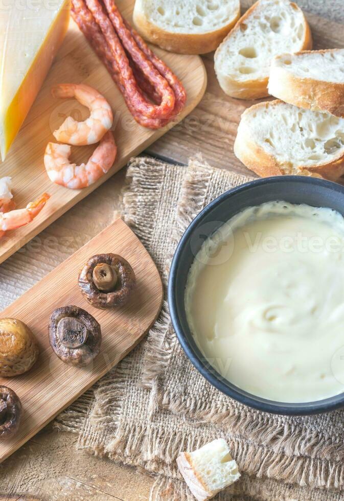 Bowl of fondue with appetizers photo