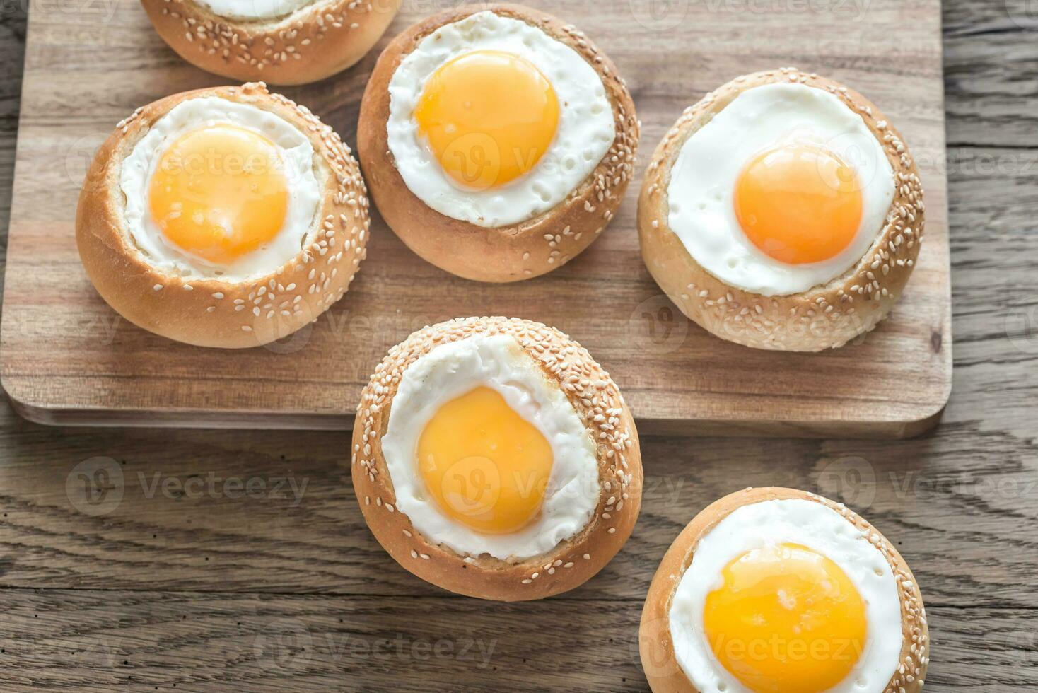 Egg-in-a-hole buns on the wooden board photo