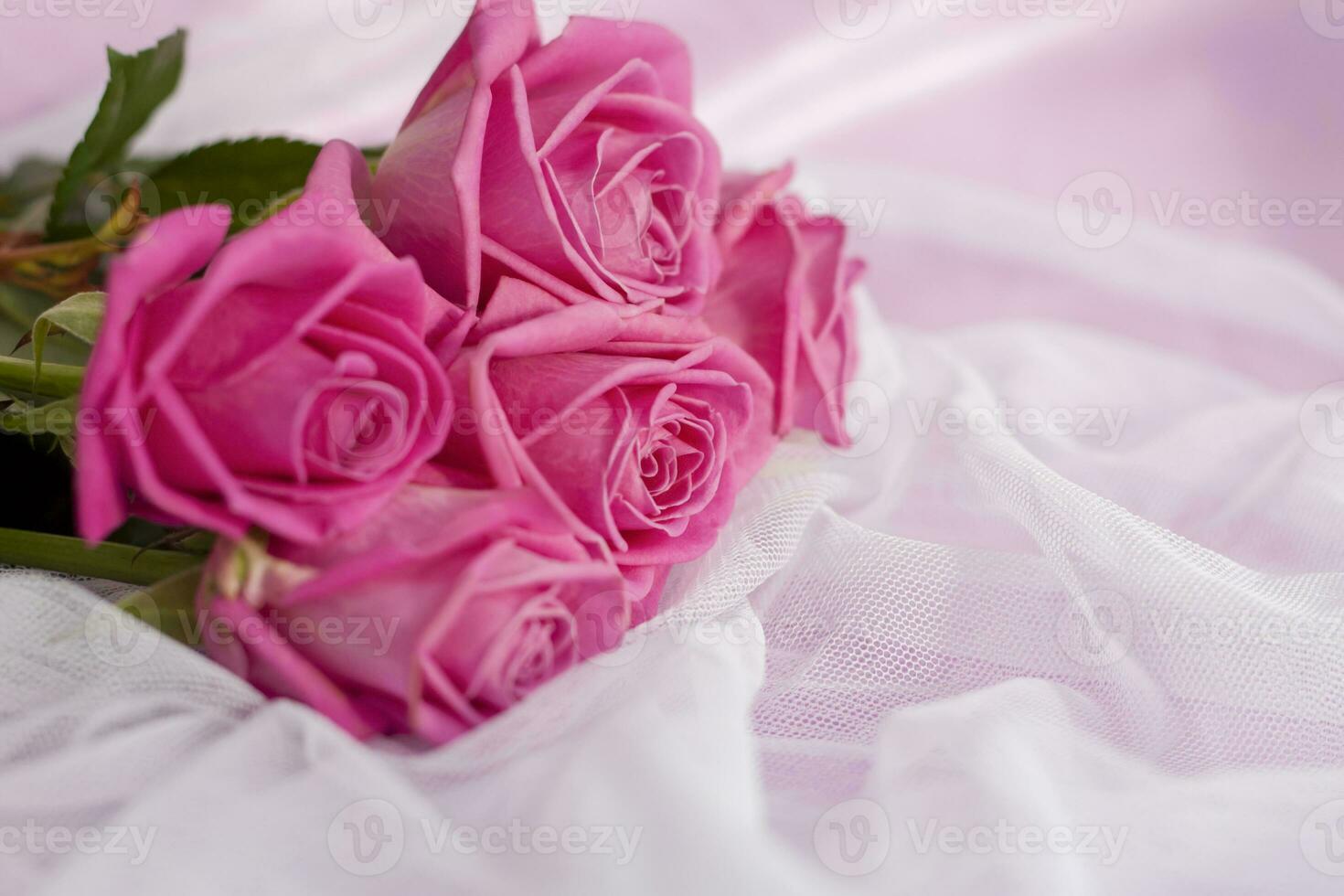 Composition with a bouquet of pink roses on a delicate fabric background. A holiday gift, pastel colors. Festive delicate background, birthday, wedding bouquet. Valentine's Day Greeting Card photo