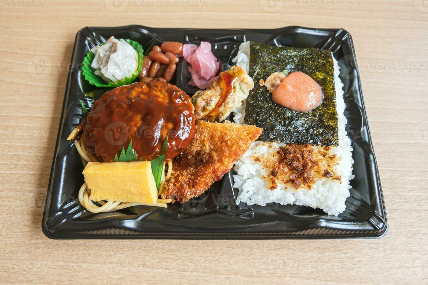 japonés bento conjunto almuerzo caja de hamburguesa bife, algas marinas en arroz, frito pescado y japonés arrollado tortilla foto