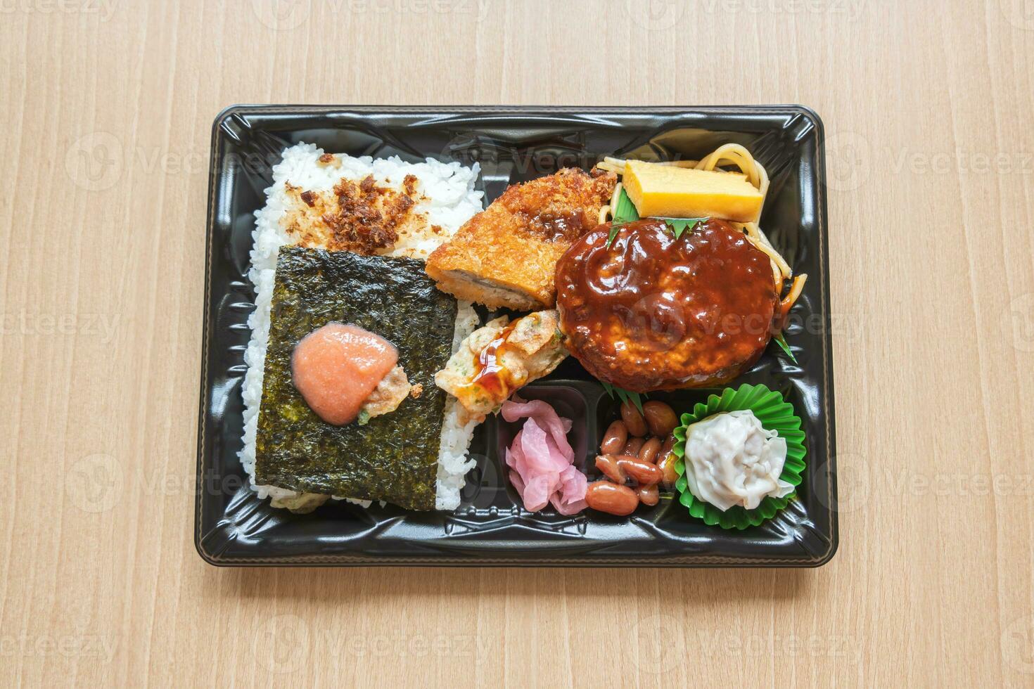 Japanese bento set lunch box of hamburger steak, seaweed on rice, fried fish and Japanese rolled omelet photo