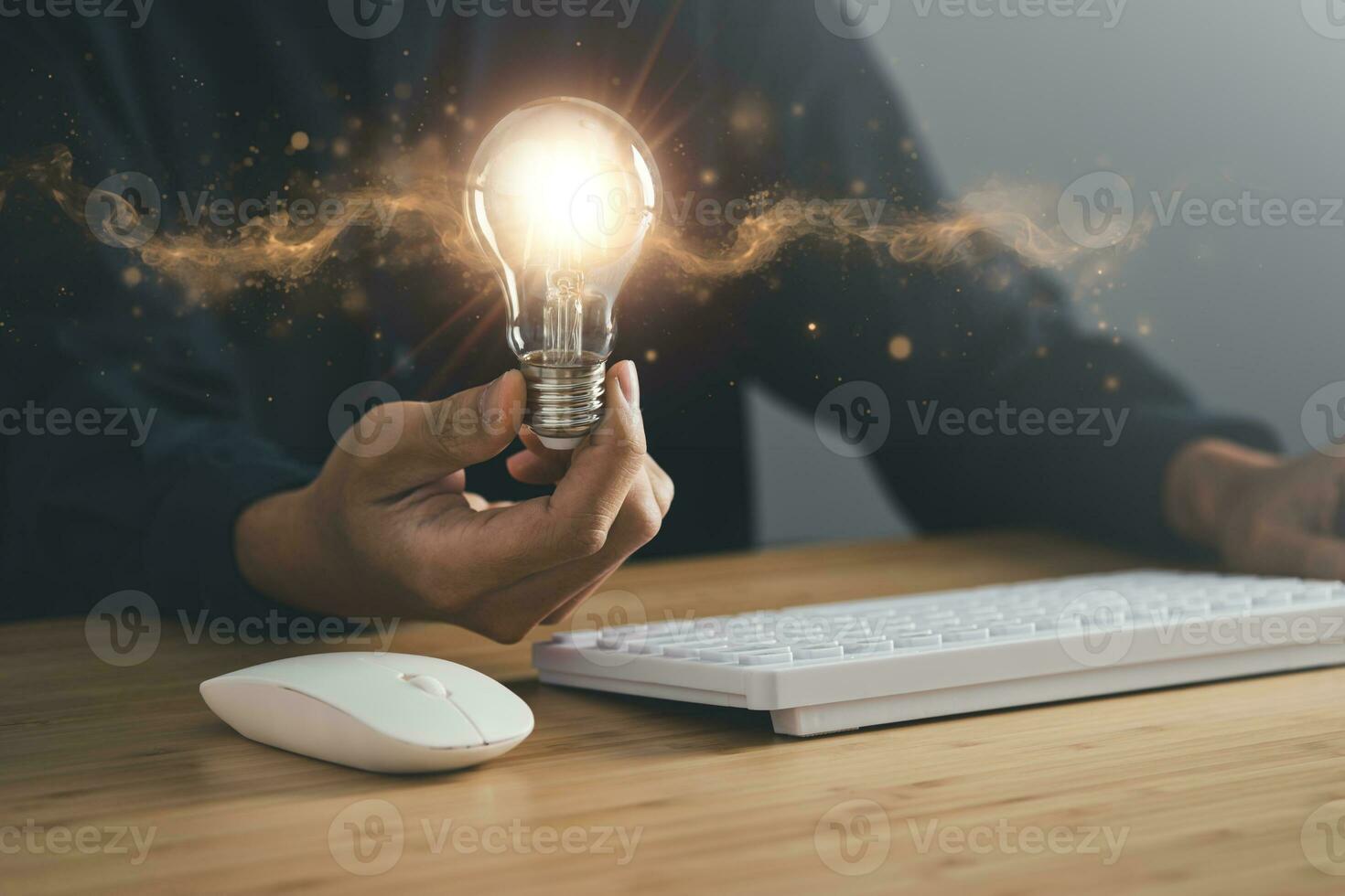 Business man holding light bulb and laptop, keyboard and mouse. New idea, innovation technology and creativity concept. photo