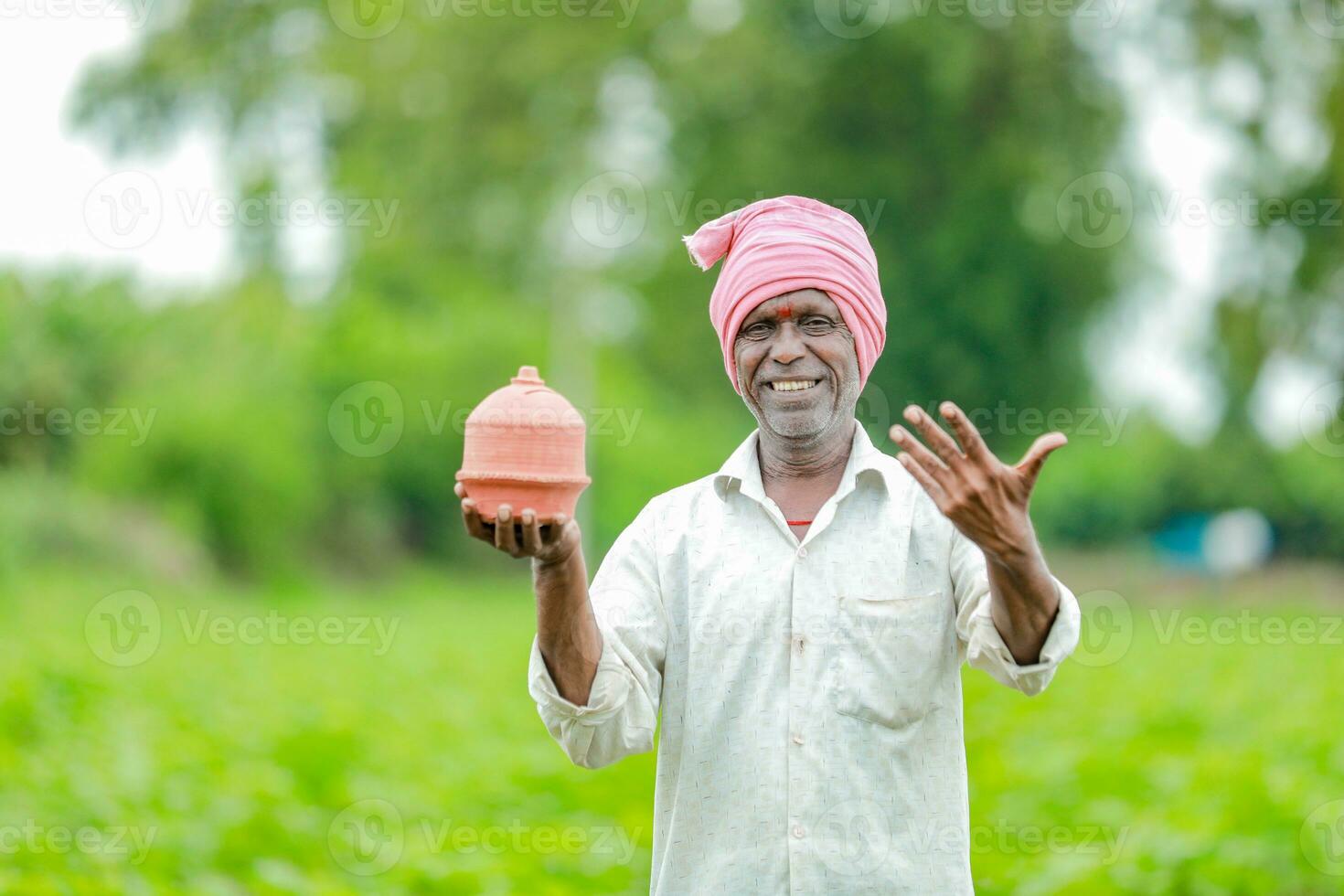 Indian farmer Holding gullak in hand, saving concept, happy poor farmer photo