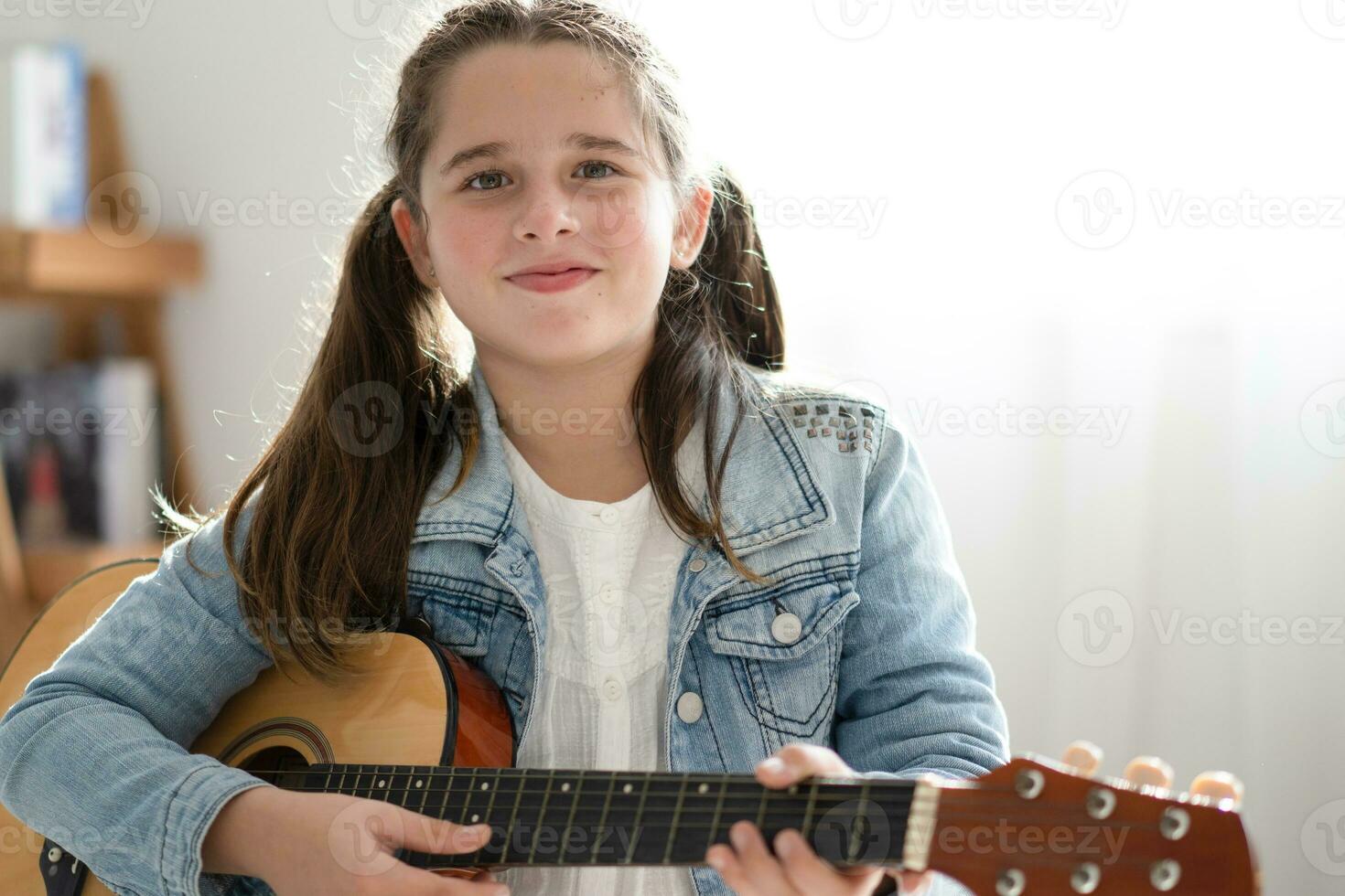 niña jugando guitarra relajarse en el dormitorio, disfrutar ocio fin de semana a hogar. libre de estrés concepto linda interpolación niña foto