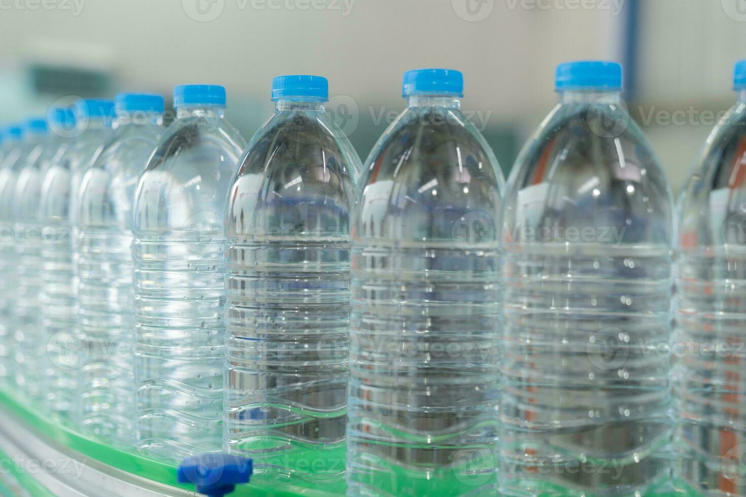 agua fábrica - agua embotellado línea para Procesando y embotellado puro mineral agua dentro azul botellas selectivo enfocar. foto