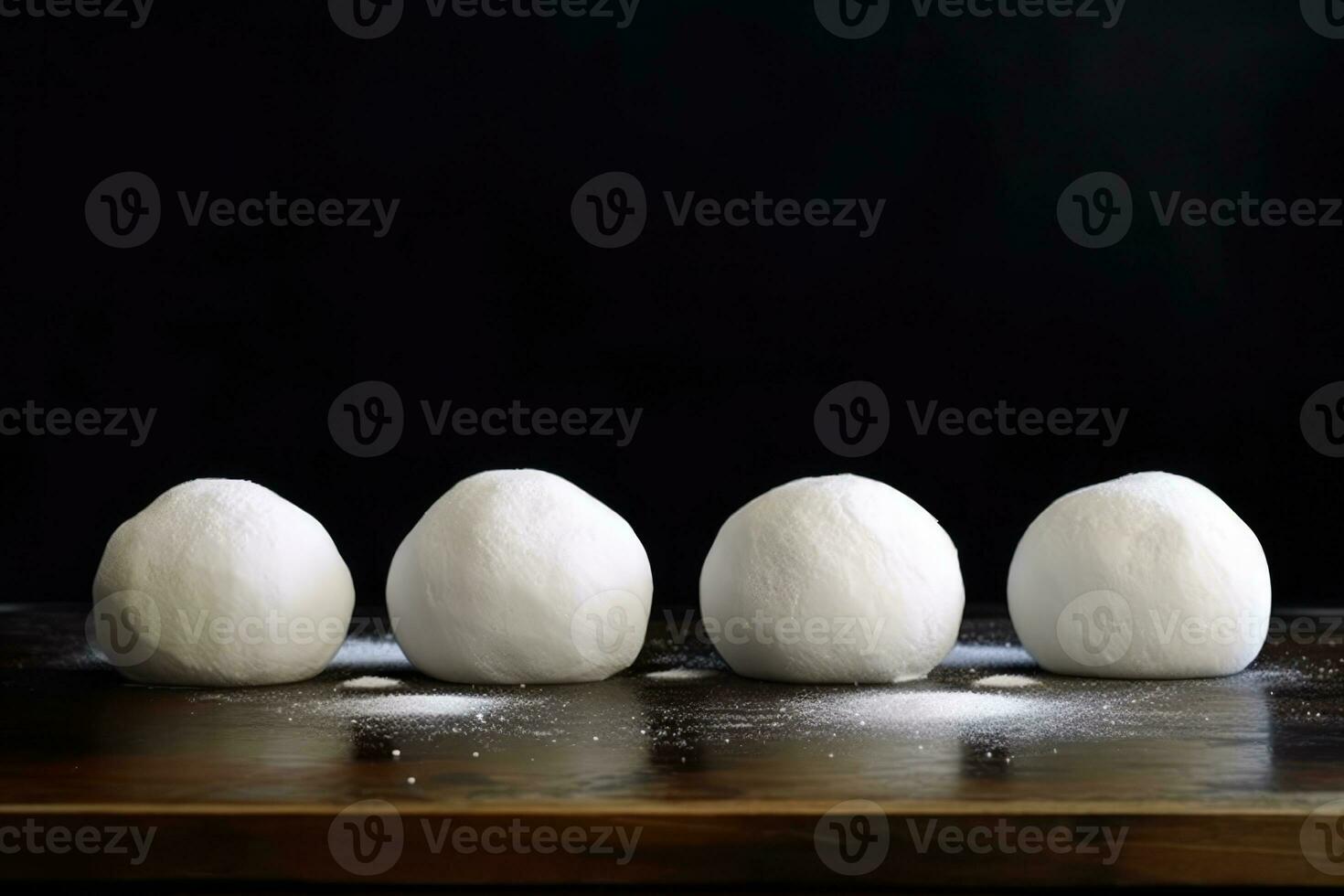 Round balls of dough lined up on a surface photo