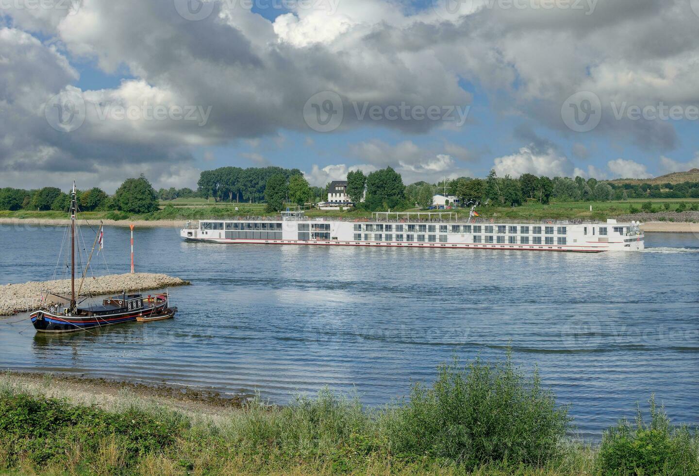 Eel Fishing Boat and River Cruise Ship on Rhine River in Monheim am Rhein,North Rhine-Westphalia,Germany photo