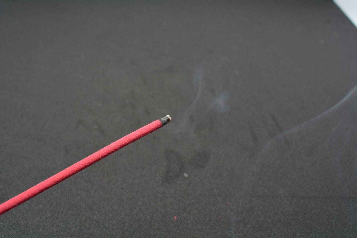 Incense stick being lit with a flame from a lighter photo