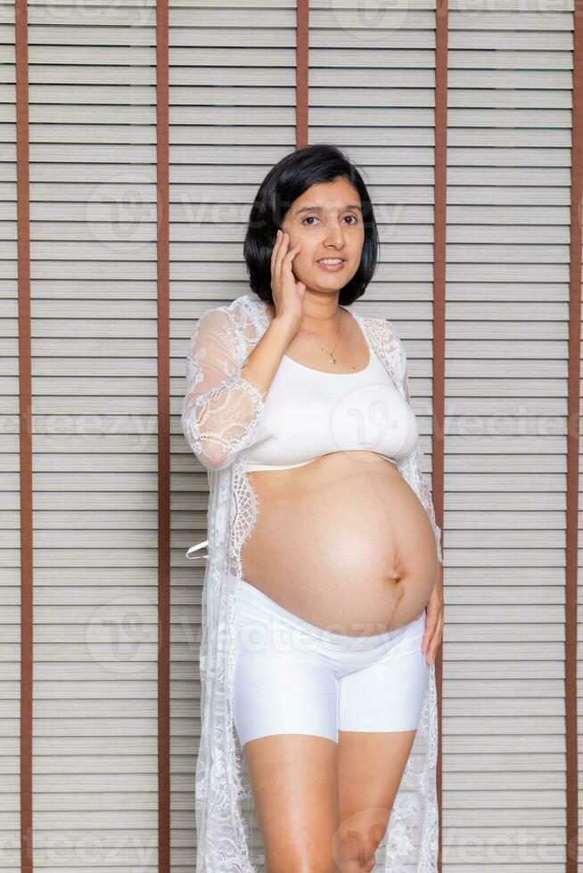 Portrait of a pregnant woman touching her big belly close up, mother, pregnancy, people and expectation. Woman holding big pregnant stomach photo