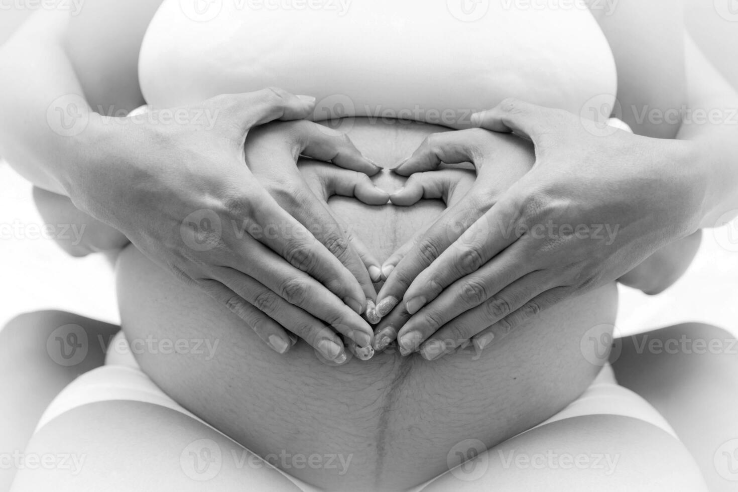 grande unido familia amor y niño nacimiento concepto. embarazada barriga con padres y niños manos. padre corazón conformado manos y pequeño niños conmovedor madre el embarazo abdomen. foto