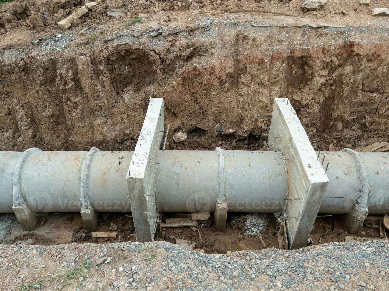 The concrete pipe under the dirt road for the irrigation system under construction. photo