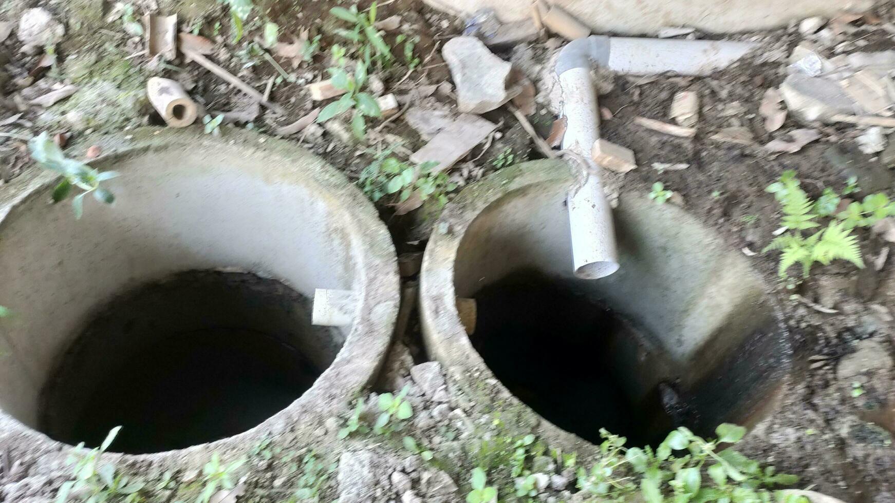 foto de dos infiltración pozos forrado arriba. infiltración pozos son usado a reducir en pie agua cuales lata dañar el edificio estructura.