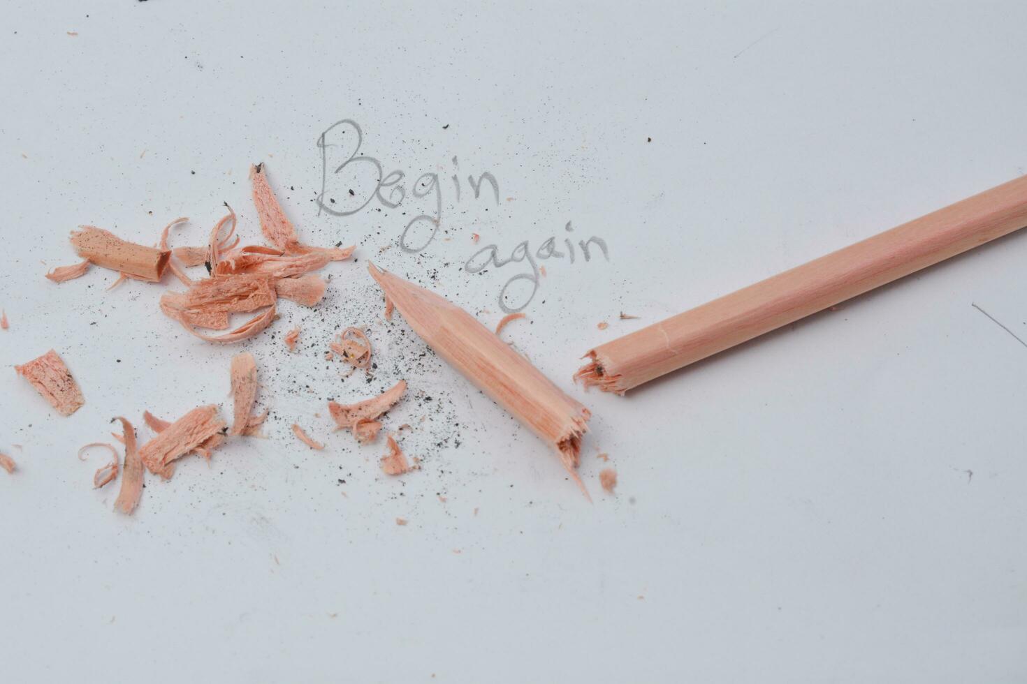 broken pencil writing with a pencil Written word begin again white background photo