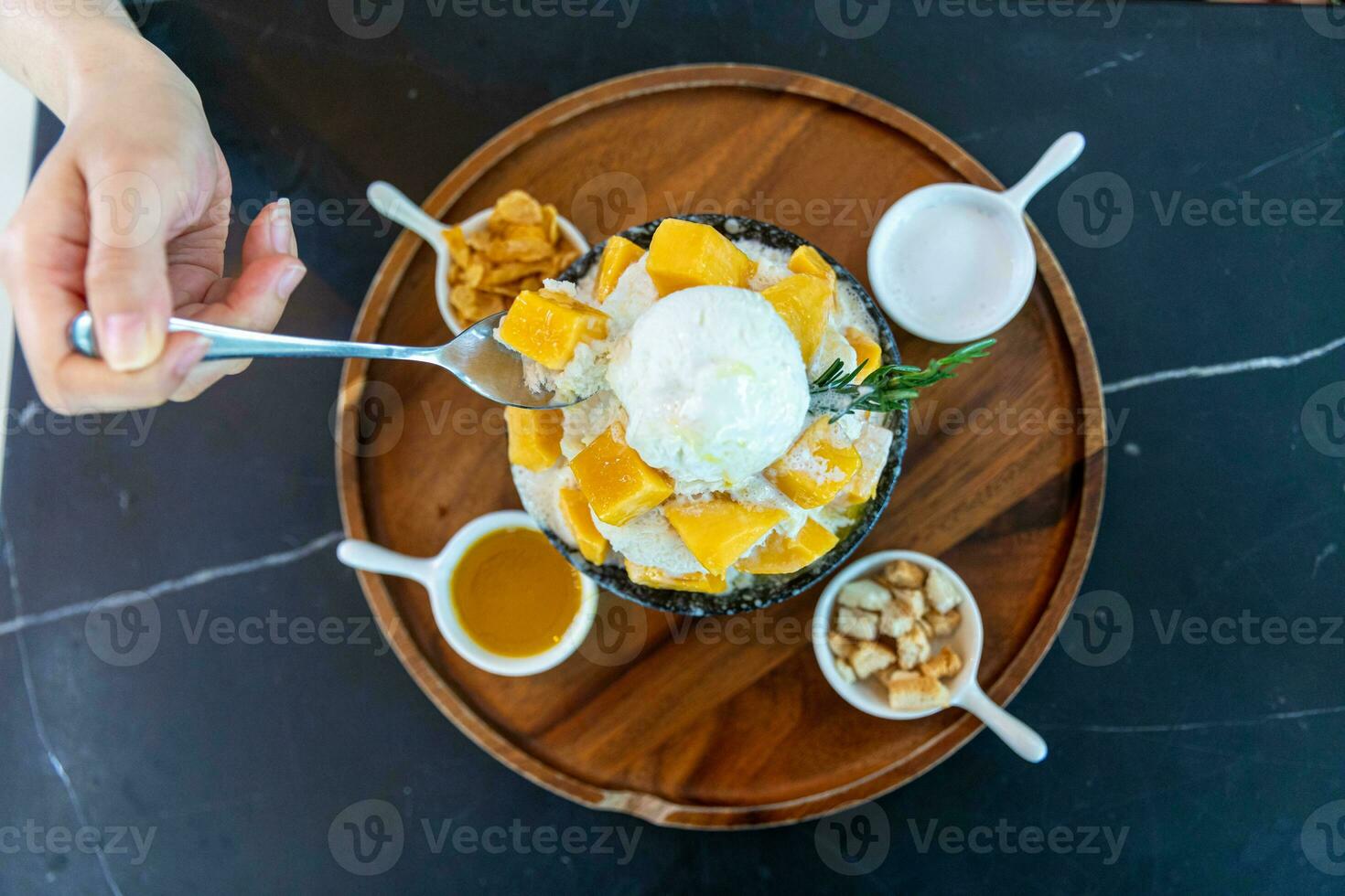 Shaved ice dessert with mango slices. Served with vanilla ice cream and whipped cream. Sweet dessert in Korean style. Local name, Bingsu. photo
