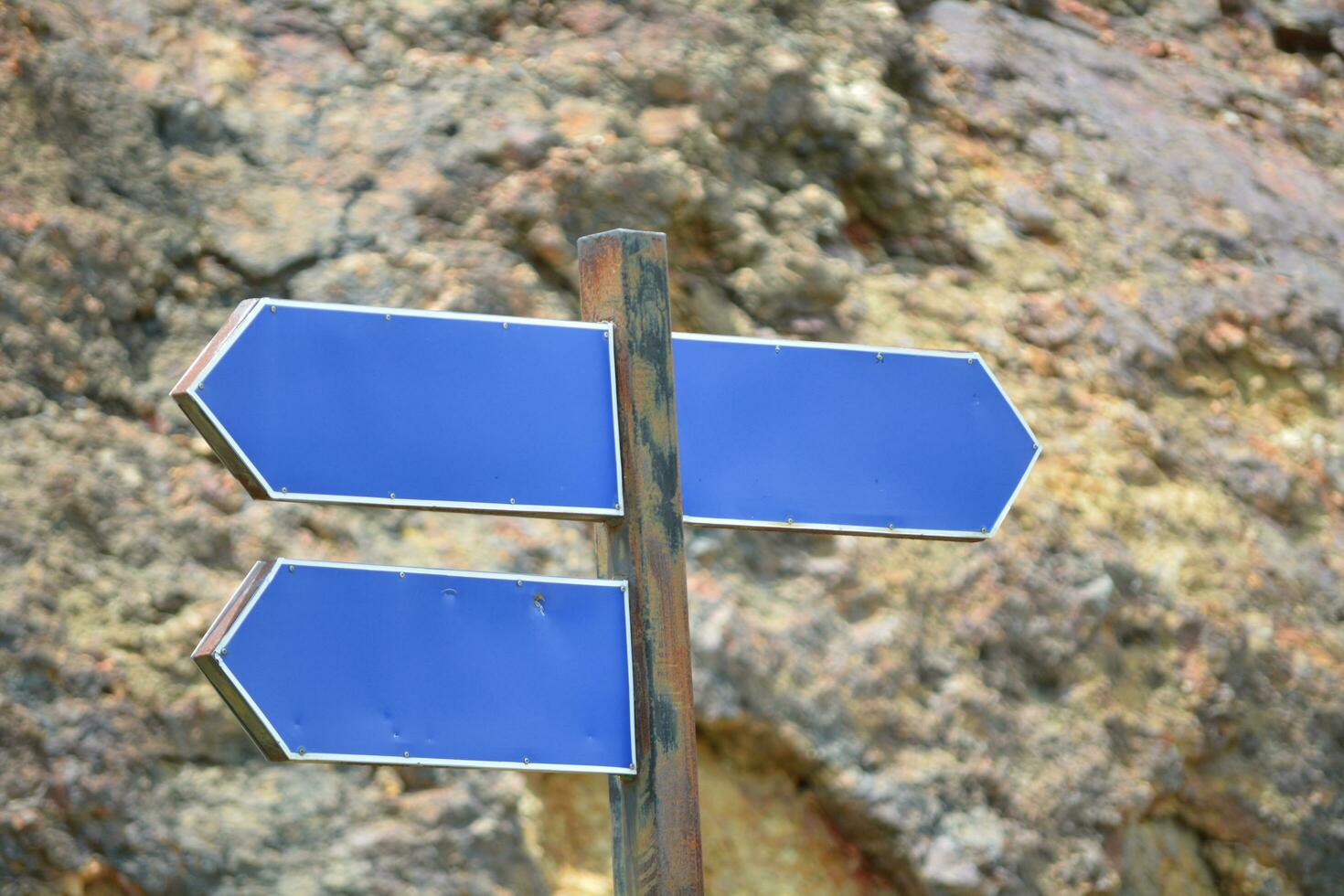 three street signs blue text plate mountain rock background Space for text. In summer, sunny in the morning. photo
