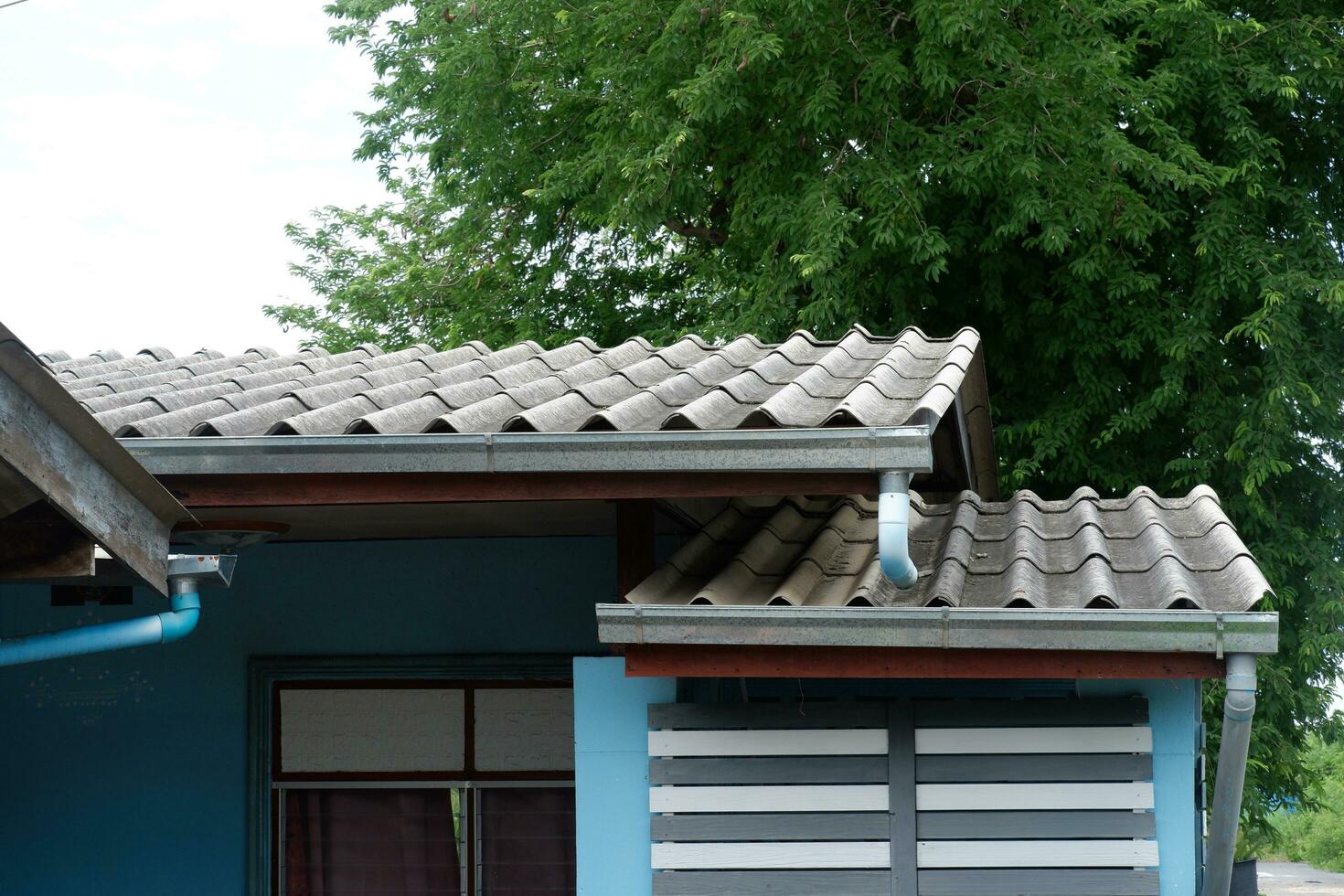 galvanizado lluvia canal, drenaje con cloruro de polivinilo tubería en frente de el casa foto