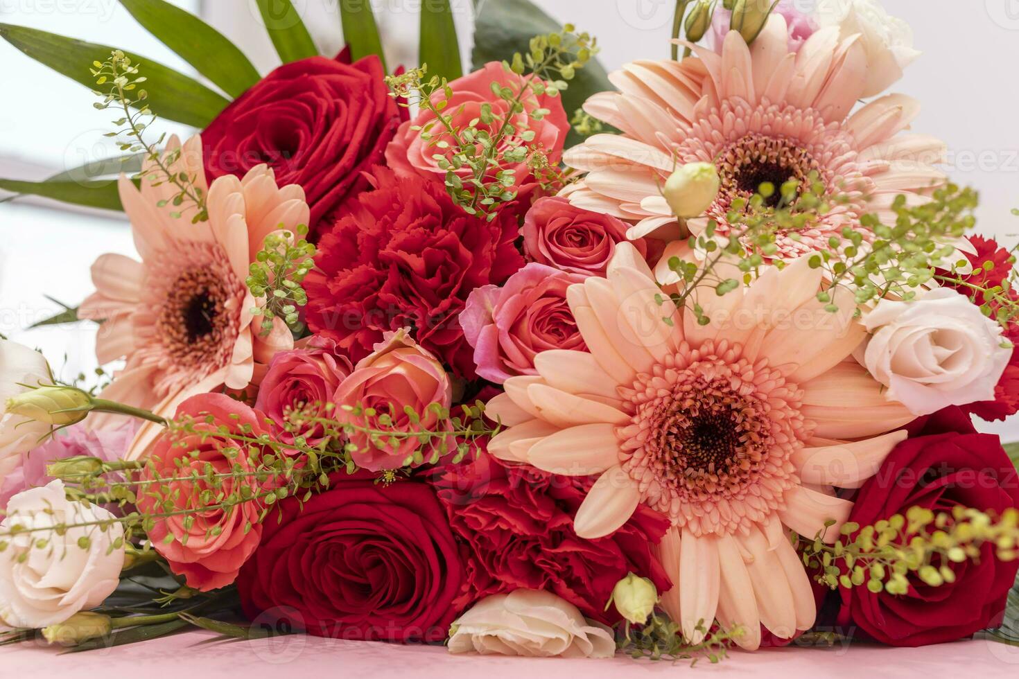 Closeup Beautiful Fresh Bouquet Of Flowers For Bride Or Occasion On Table. Colorful Mixed Roses, Carnation Shabot, Green Leaves, Gerber. Horizontal photo