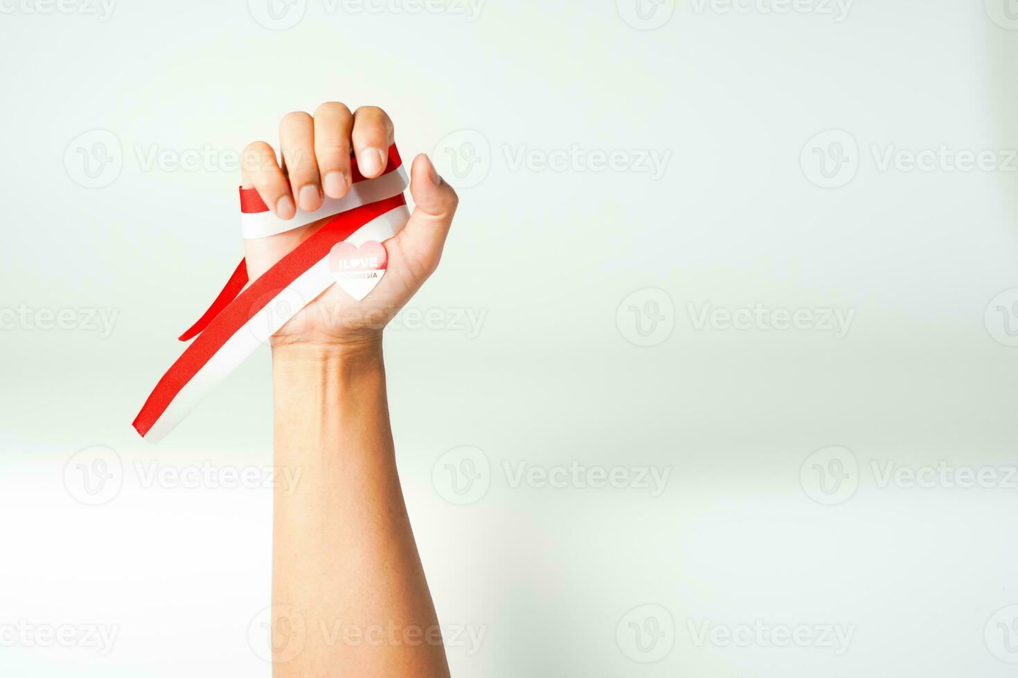hand holding ribbon, red and white flag of Indonesia independence day August 17th, i love indonesia, isolated on white background. photo