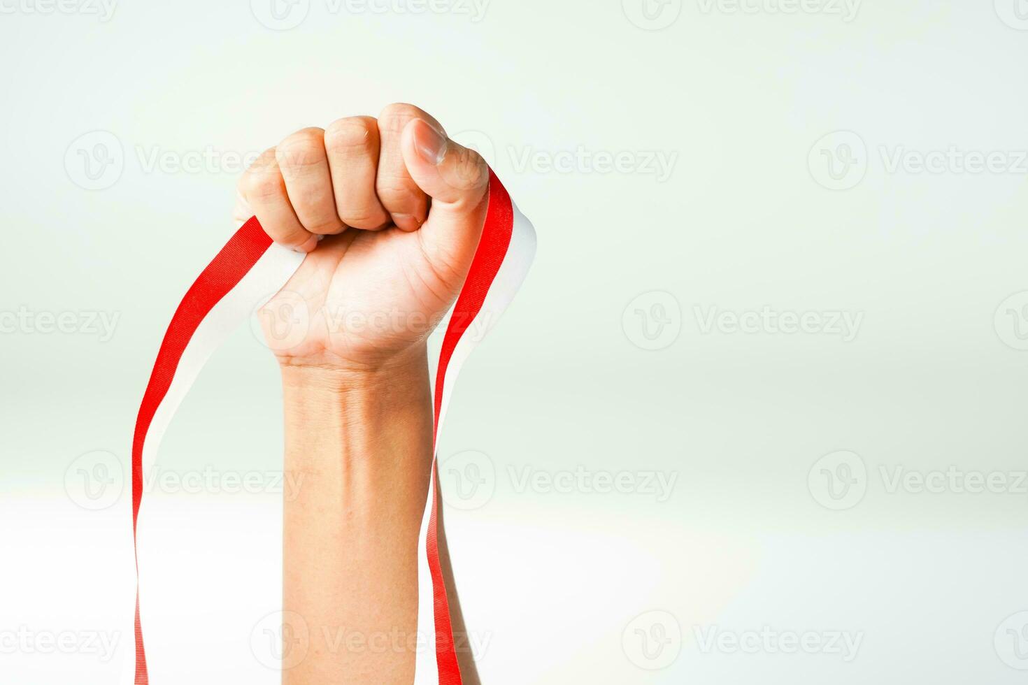 hand holding ribbon, red and white flag of Indonesia independence day August 17th, i love indonesia, isolated on white background. photo