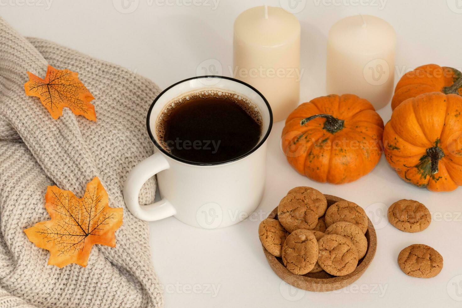 Mañana café, otoño atmósfera. taza, bufanda, galletas, calabazas y velas en mesa foto