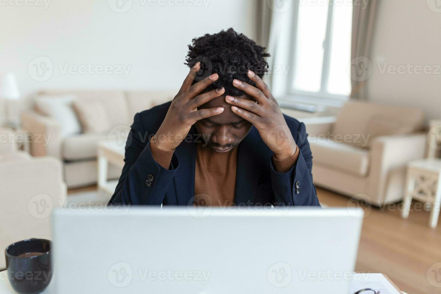 Stressed tired African American man touching temples, suffering from headache after long hours work, overworked overwhelmed businessman sitting at desk, feeling unwell photo