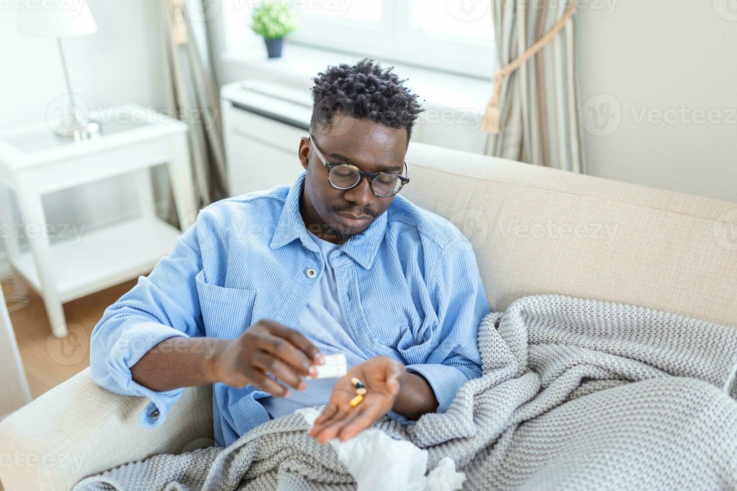 sick wasted man lying in bed suffering cold and winter flu virus having medicine tablets in health care concept Drinking pills with glass of water photo