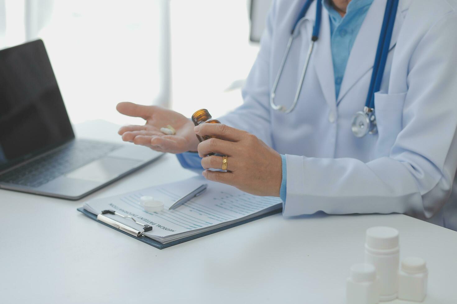 Doctor giving hope. Close up shot of young female physician leaning forward to smiling elderly lady patient holding her hand in palms. Woman caretaker in white coat supporting encouraging old person photo