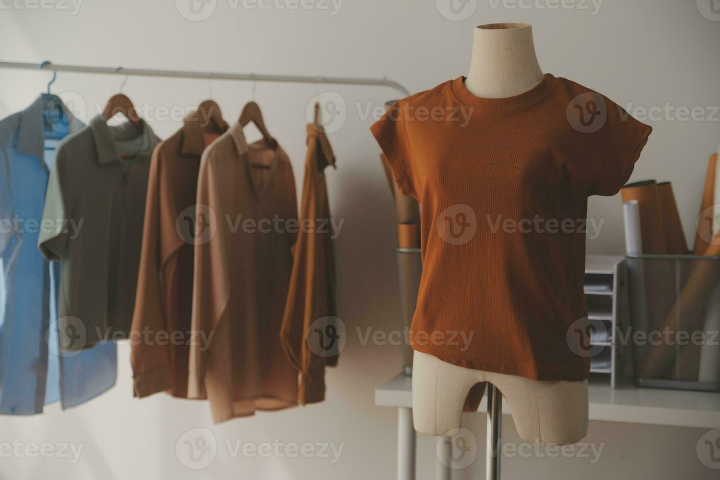 A few finishing touches and itll be ready. Shot of a young fashion designer working on a garment hanging over a mannequin. photo