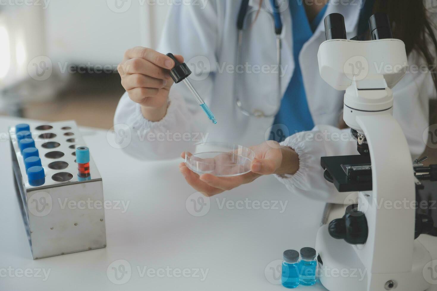 Professional lab. Amazing longhaired medical worker wearing uniform while using microscope during research photo