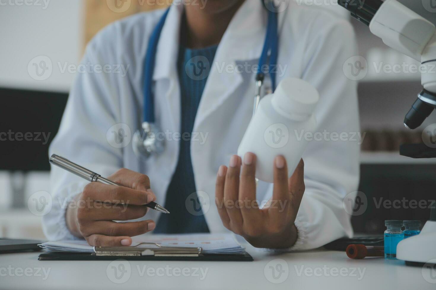 Professional lab. Amazing longhaired medical worker wearing uniform while using microscope during research photo