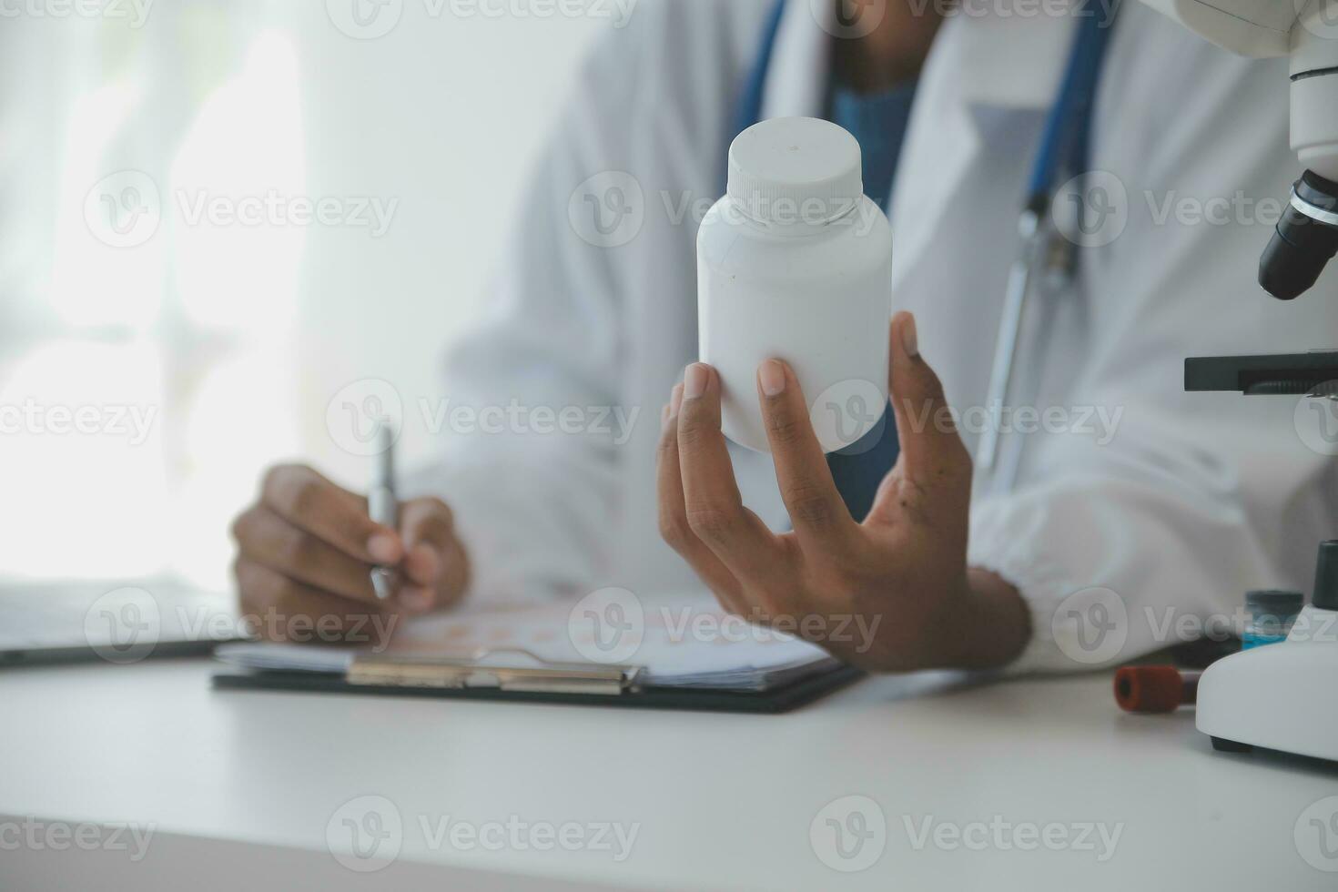 Professional lab. Amazing longhaired medical worker wearing uniform while using microscope during research photo