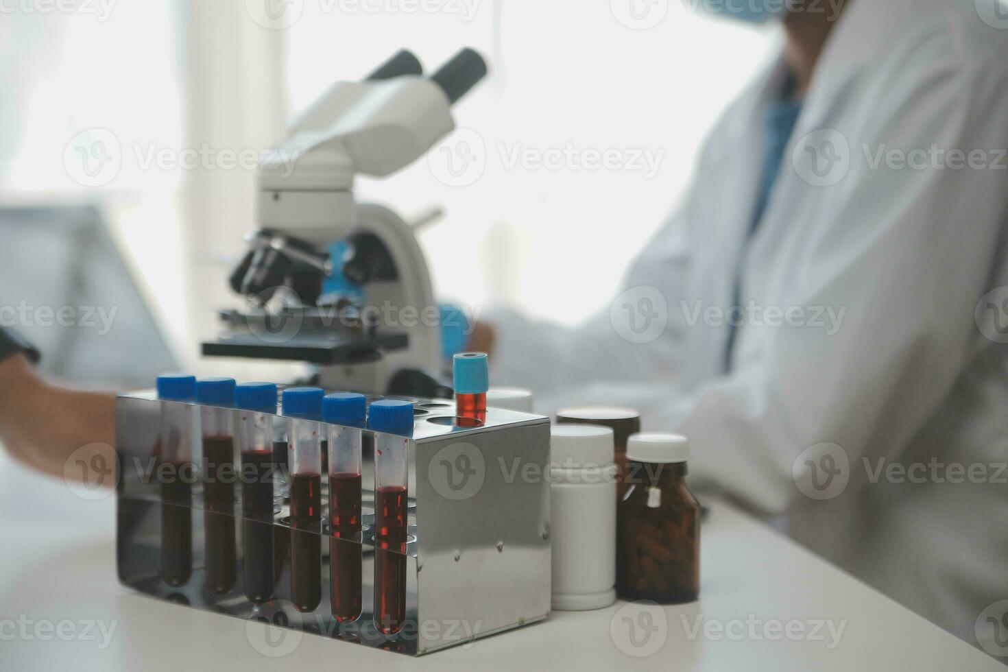 Professional lab. Amazing longhaired medical worker wearing uniform while using microscope during research photo