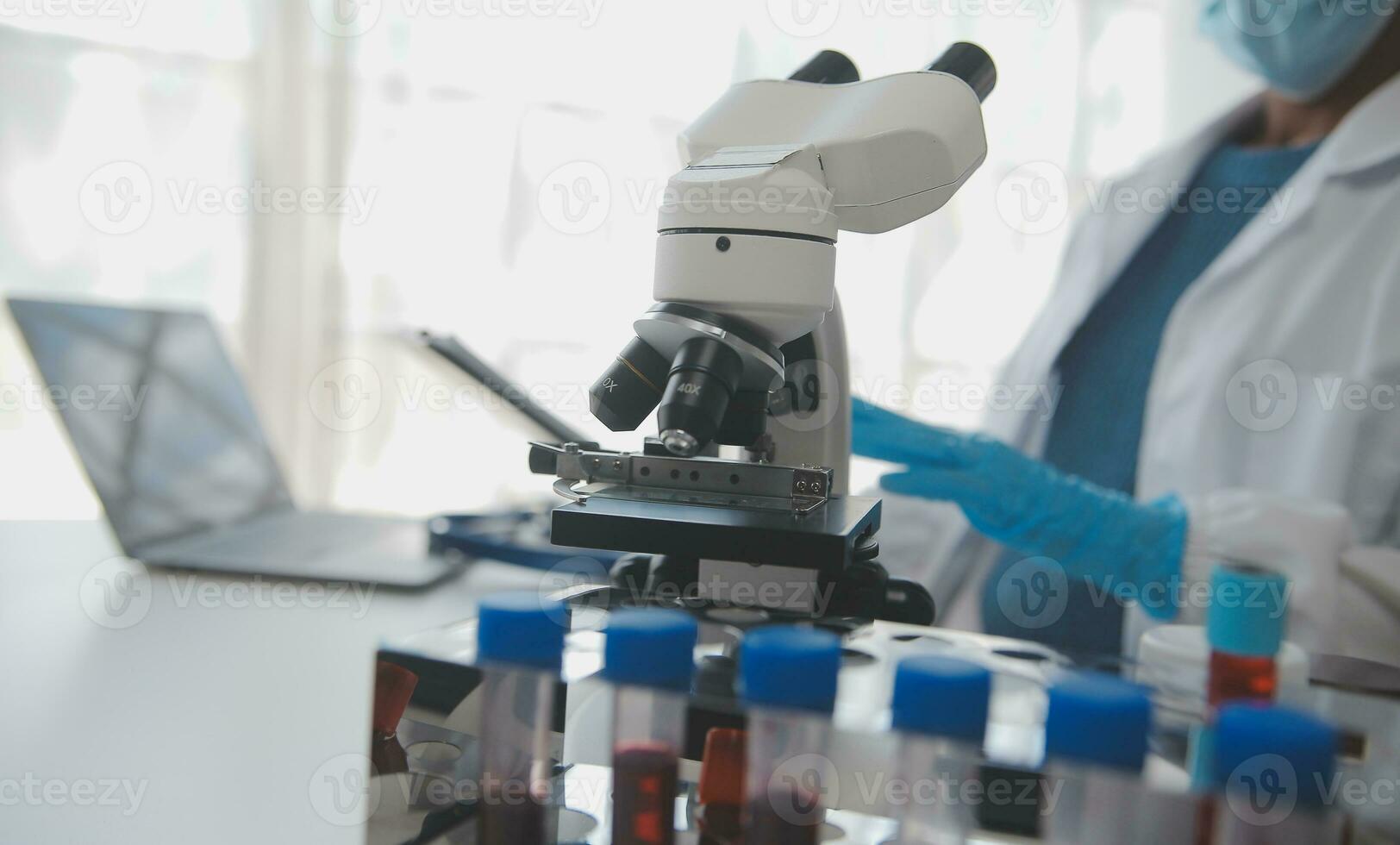 Professional lab. Amazing longhaired medical worker wearing uniform while using microscope during research photo