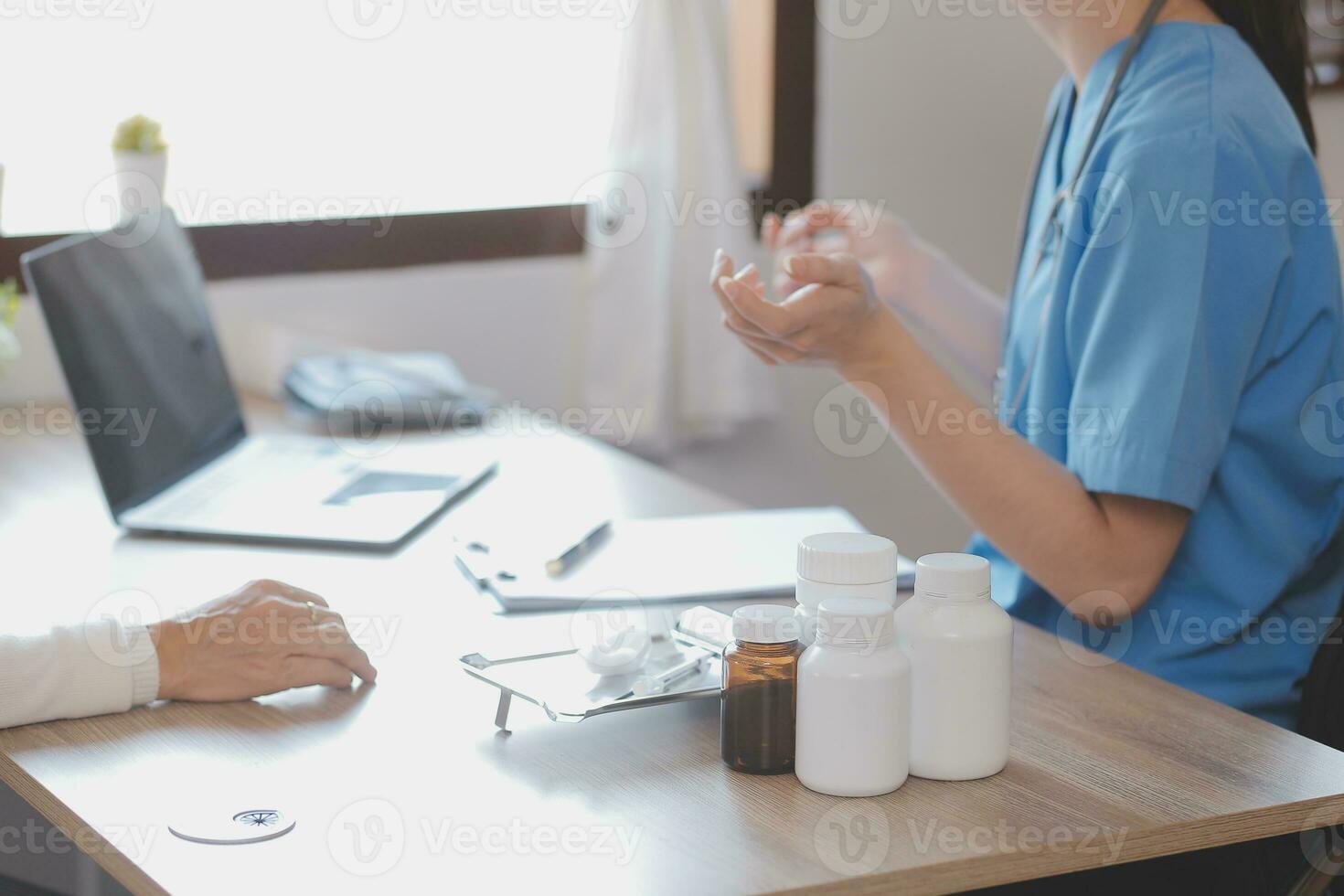 Doctor and patient talking while sitting at the desk in hospital office, closeup of human hands. Medicine and health care concept photo