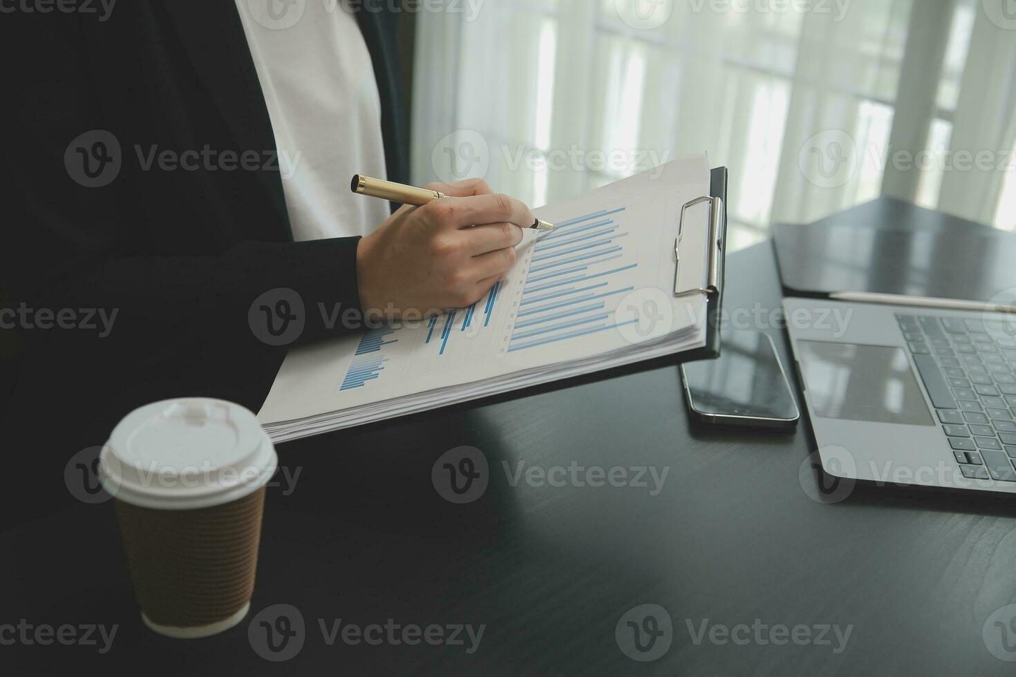 Asian Business woman using calculator and laptop for doing math finance on an office desk, tax, report, accounting, statistics, and analytical research concept photo