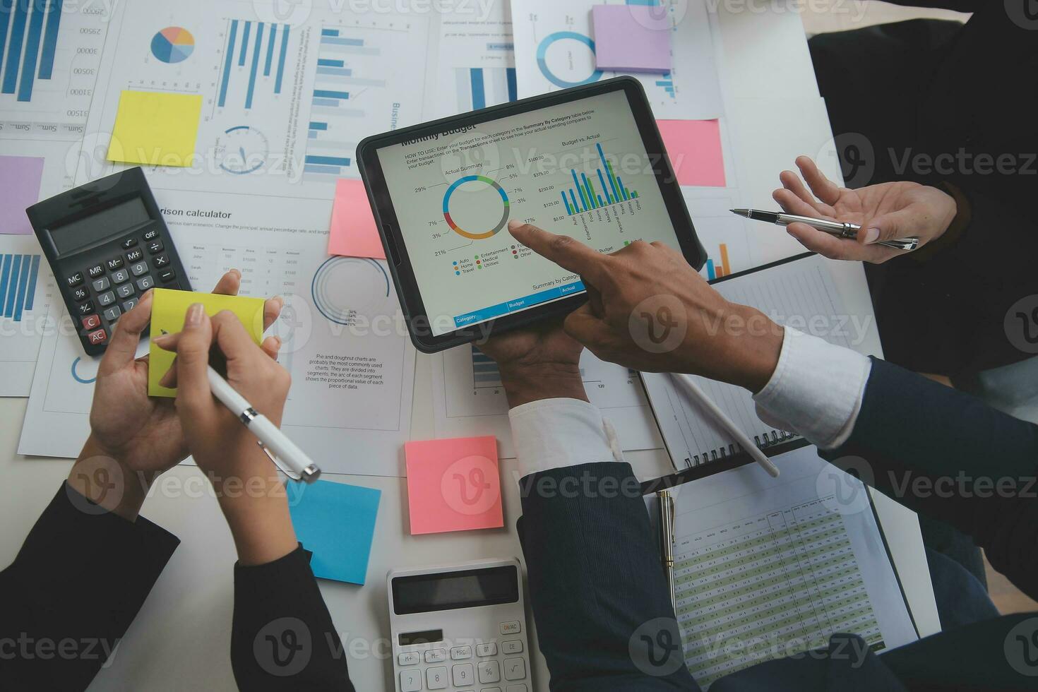 Financial analysts analyze business financial reports on a digital tablet planning investment project during a discussion at a meeting of corporate showing the results of their successful teamwork. photo