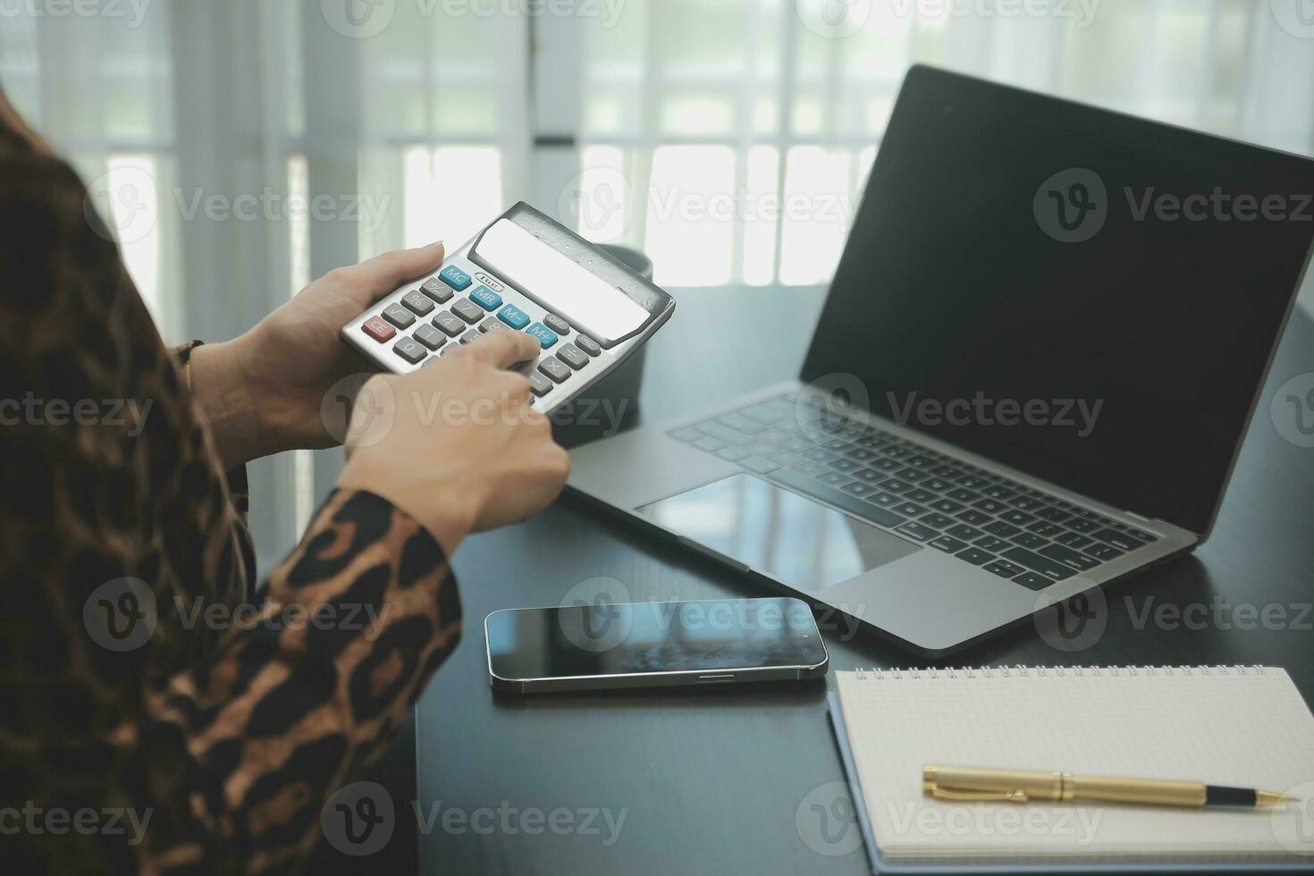 Asian Business woman using calculator and laptop for doing math finance on an office desk, tax, report, accounting, statistics, and analytical research concept photo