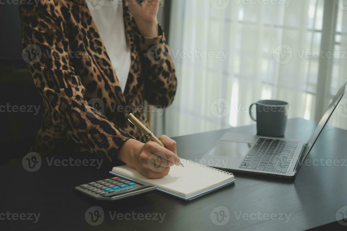 Asian Business woman using calculator and laptop for doing math finance on an office desk, tax, report, accounting, statistics, and analytical research concept photo