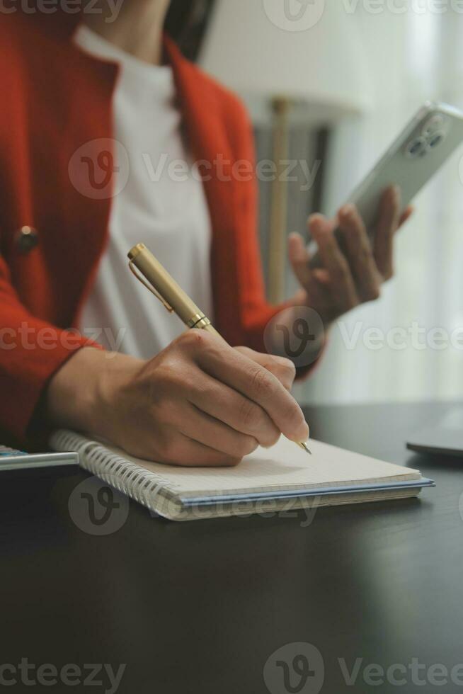 Asian Business woman using calculator and laptop for doing math finance on an office desk, tax, report, accounting, statistics, and analytical research concept photo