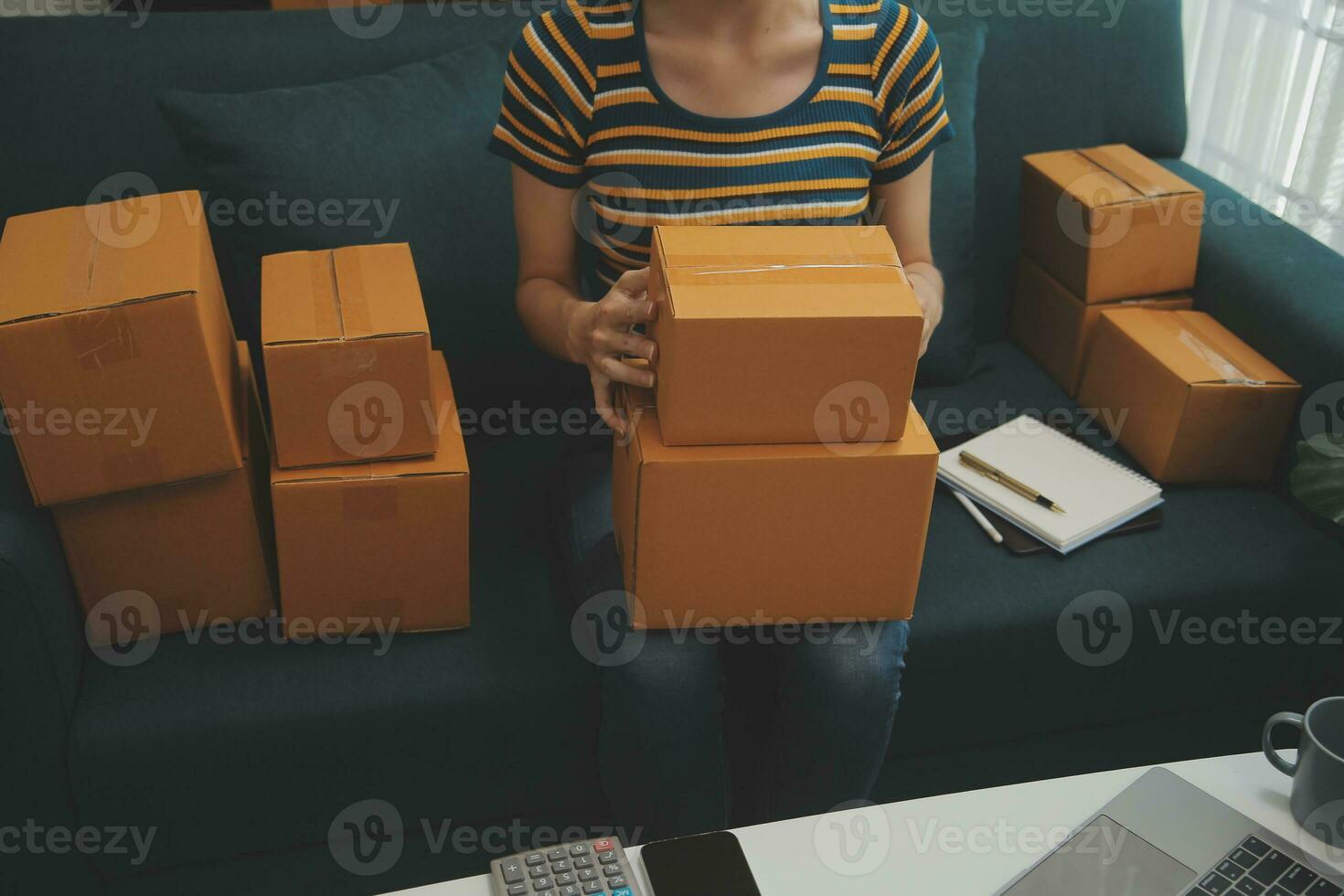 SME entrepreneur Small business entrepreneurs Online selling ideas,Happy Young Asian business owner work on computer and a boxs at home,delivery SME procurement package box deliver to customers, photo