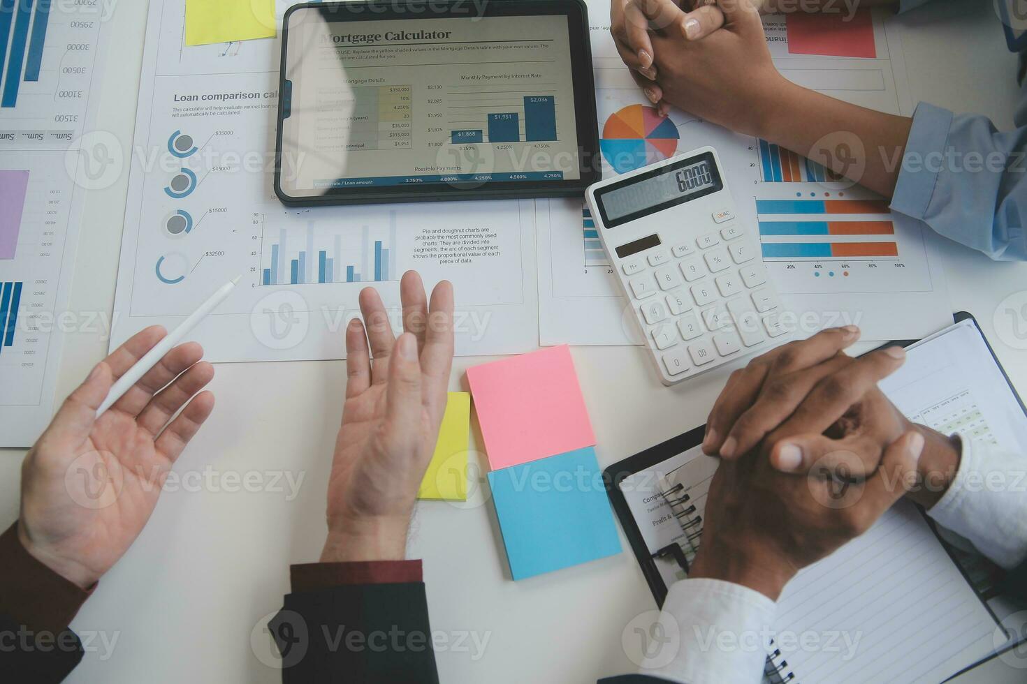 Financial analysts analyze business financial reports on a digital tablet planning investment project during a discussion at a meeting of corporate showing the results of their successful teamwork. photo