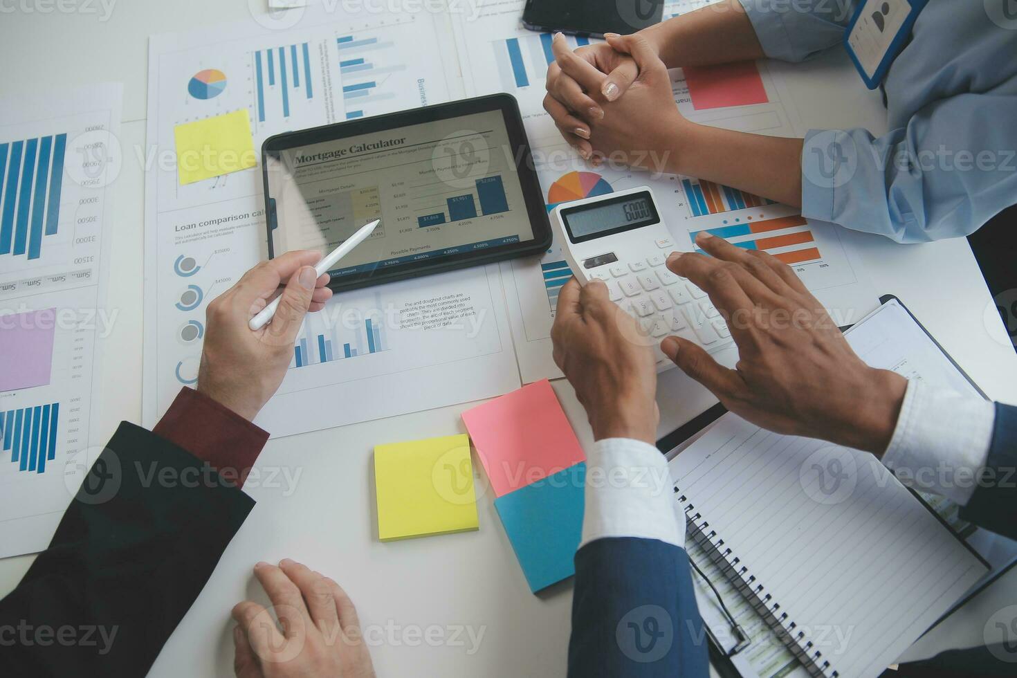 Financial analysts analyze business financial reports on a digital tablet planning investment project during a discussion at a meeting of corporate showing the results of their successful teamwork. photo