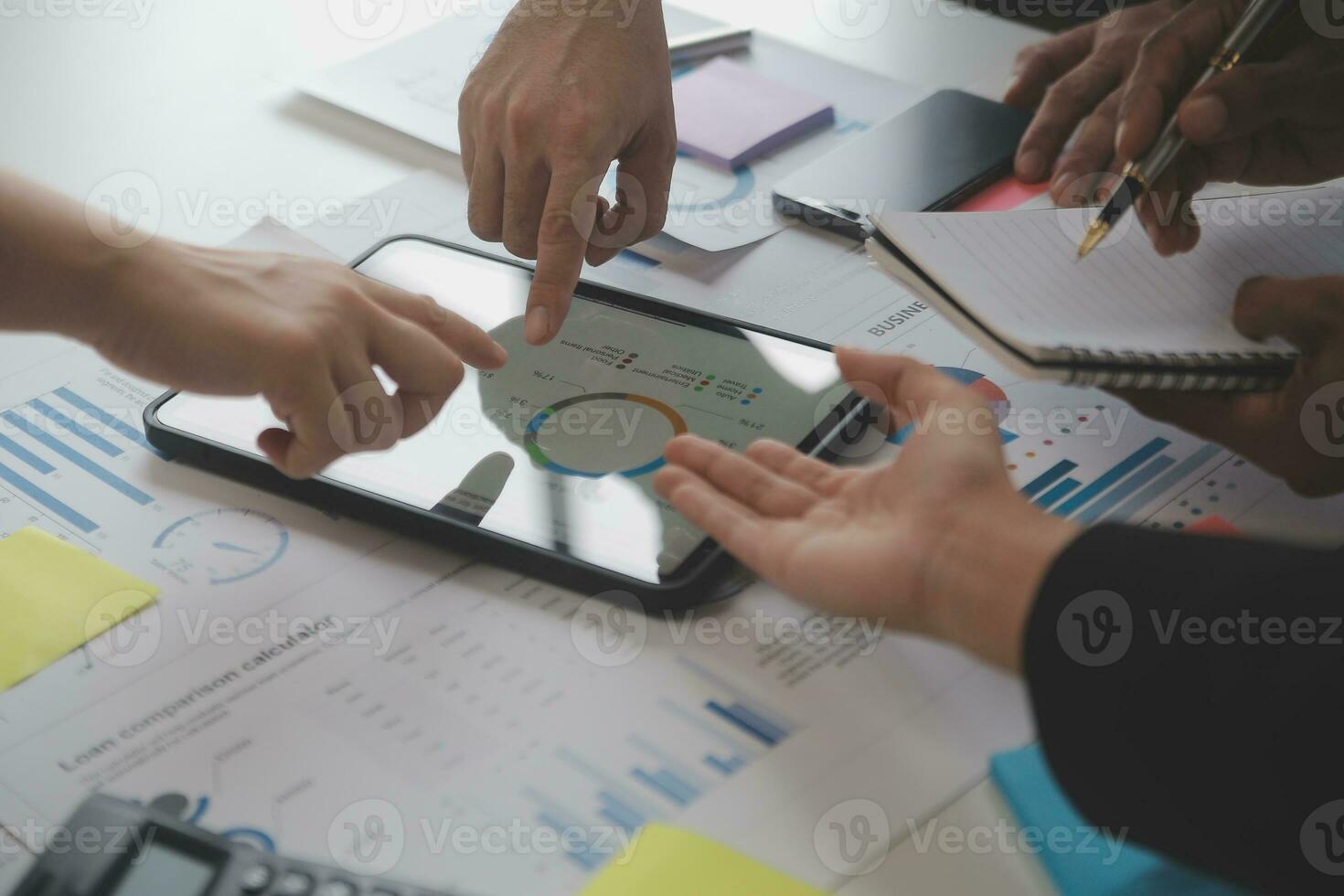 Financial analysts analyze business financial reports on a digital tablet planning investment project during a discussion at a meeting of corporate showing the results of their successful teamwork. photo