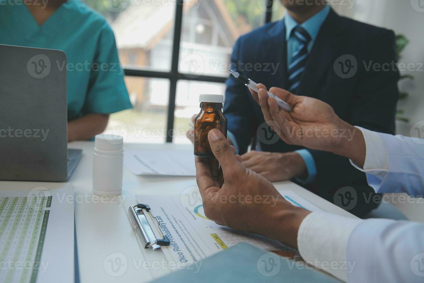 medical team having a meeting with doctors in white lab coats and surgical scrubs seated at a table discussing a patients records,success medical health care, Medicine doctor's working concept photo